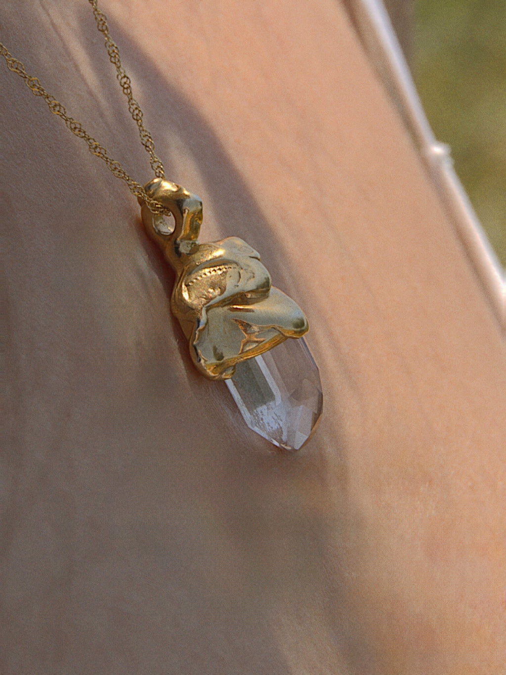 Gold vermeil pendant with crystal, hand-carved myth-inspired design worn on chain