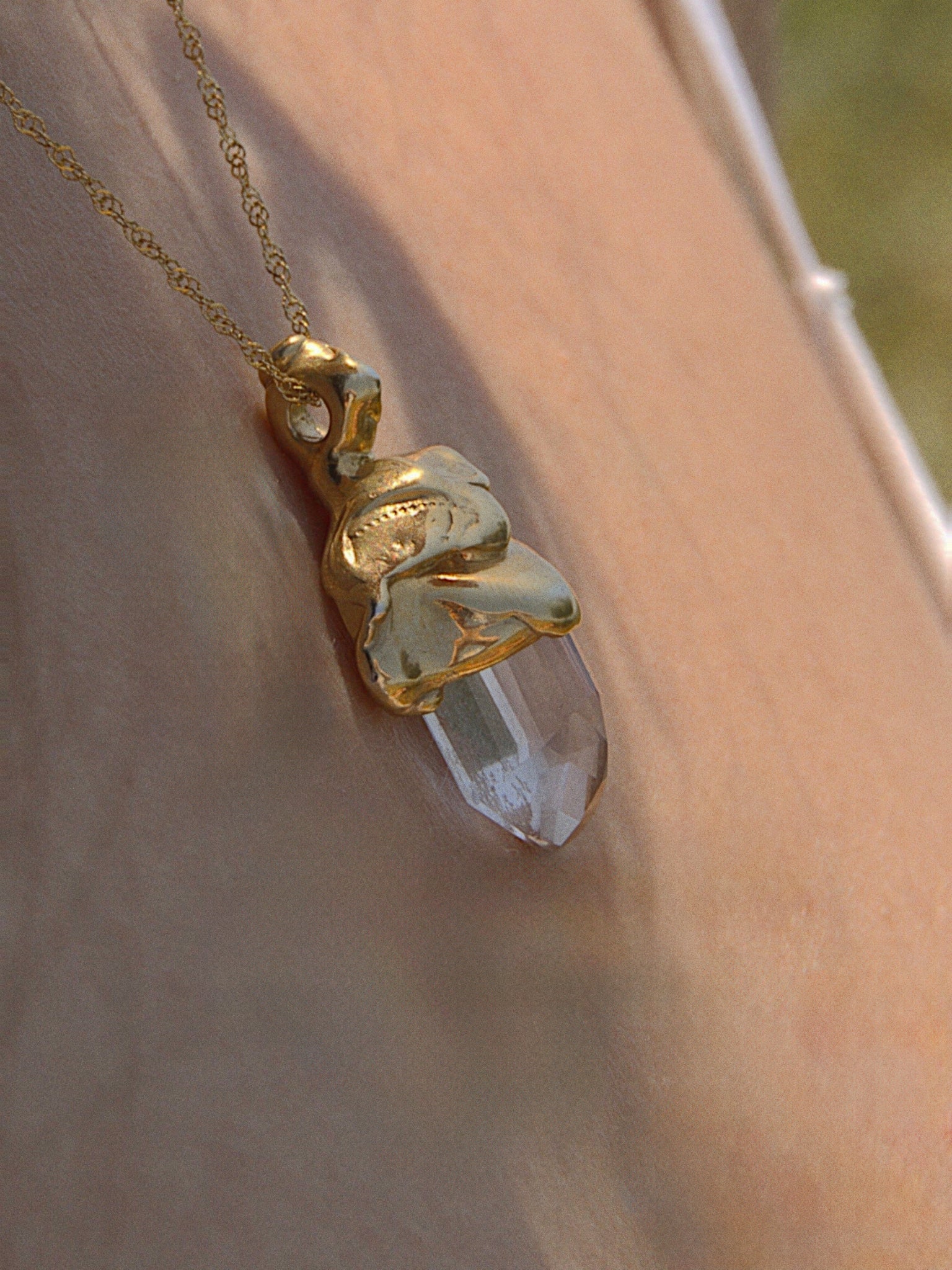 Gold vermeil pendant with crystal, hand-carved myth-inspired design worn on chain
